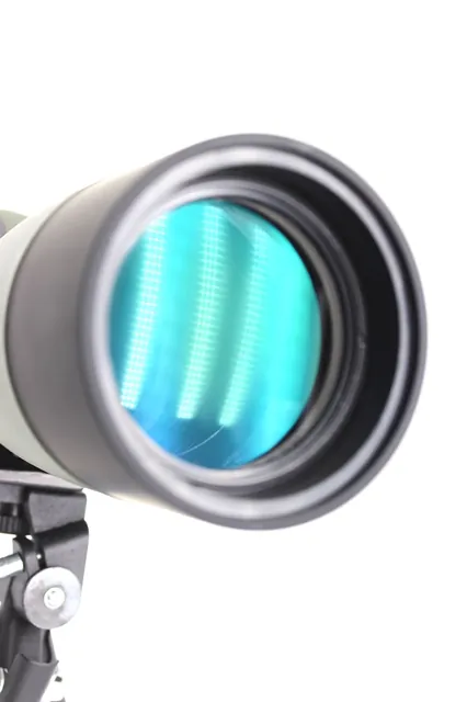 Close up of an optical lens with a blue-green anti-reflective coating, mounted on a black bracket