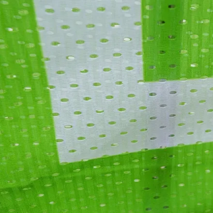 Mesh banner displayed at an outdoor festival with wind passing through