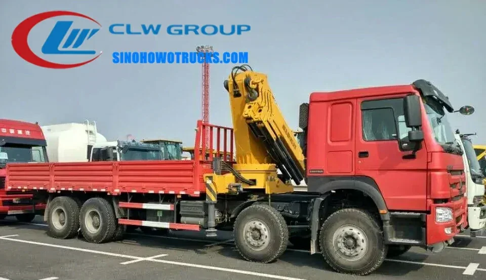 12 wheel Sinotruk HOWO 15 ton knuckle boom truck in construction site with crane extended and boom at 360 degree rotation