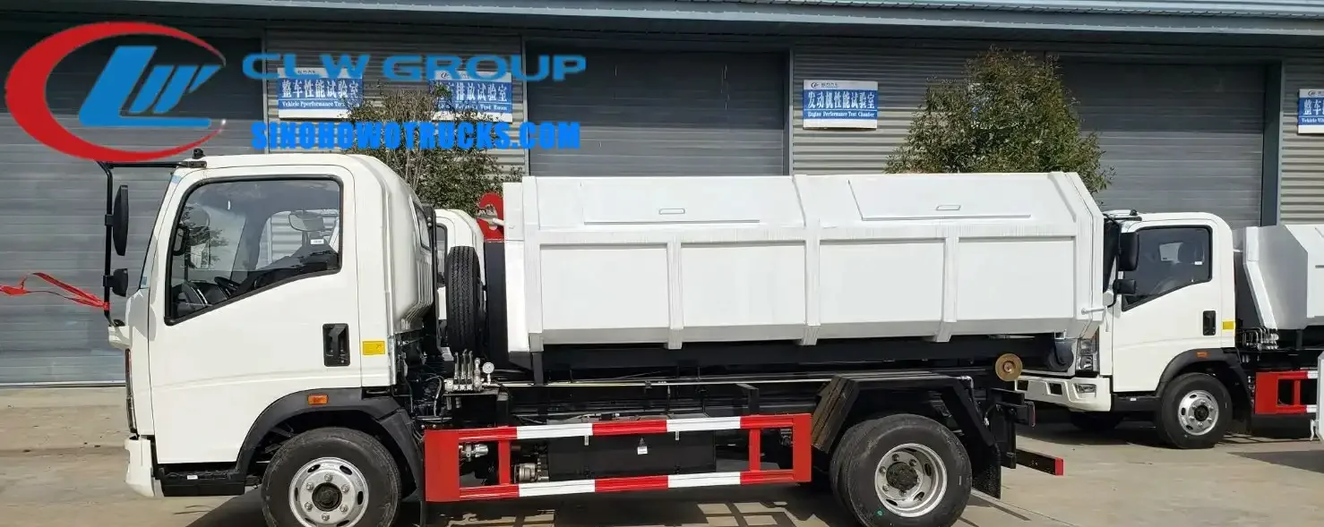 HOWO 5m3 mini hook loader garbage truck with detachable hopper in urban waste collection setting