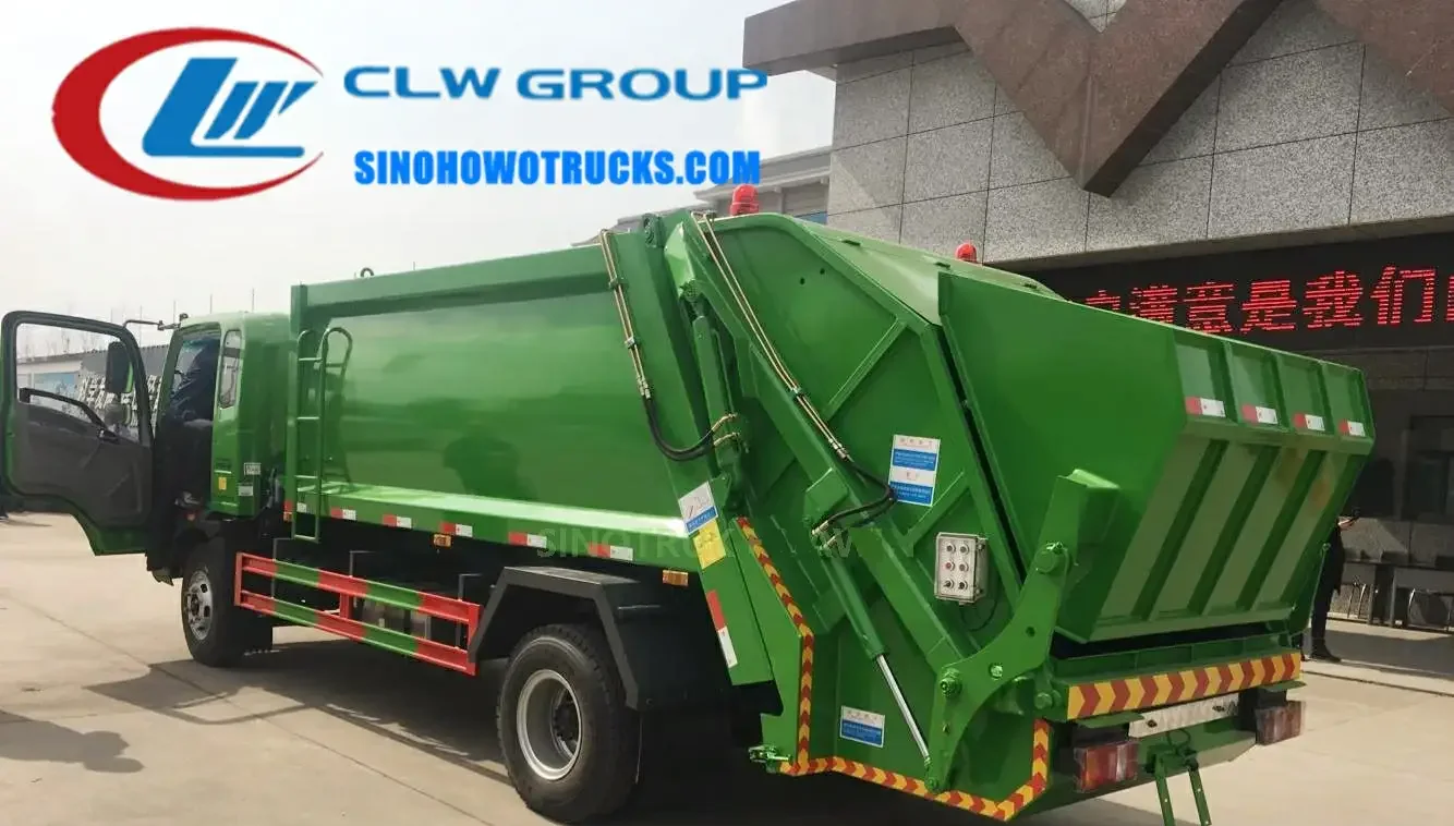 Sinotruk HOWO 6 ton rear loading rubbish truck in urban waste collection service with rear compaction door open