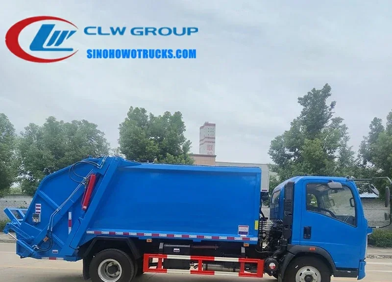 HOWO Light Duty rear load garbage truck in urban waste collection setting with rear loading mechanism in use