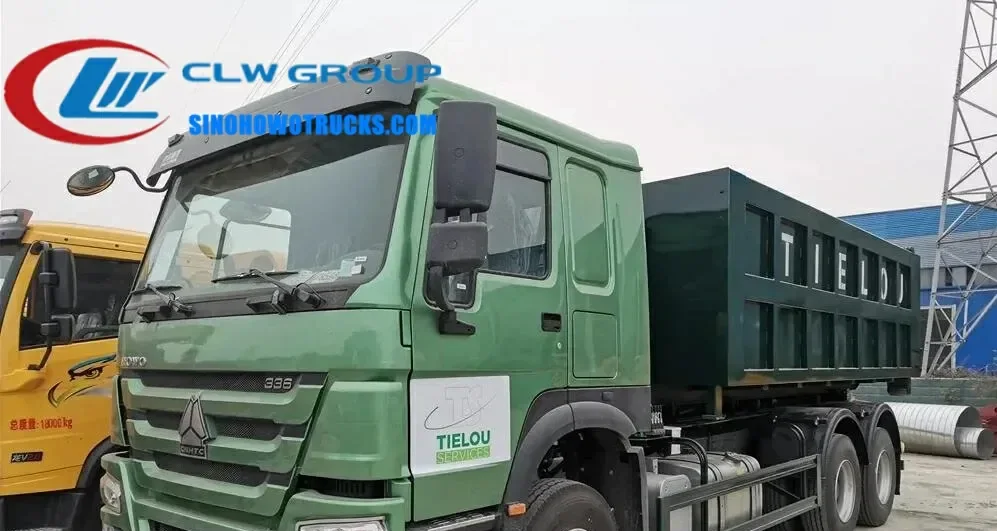 Sinotruk HOWO 6x4 roll off dump truck in urban waste collection service with 16m³ container being lifted