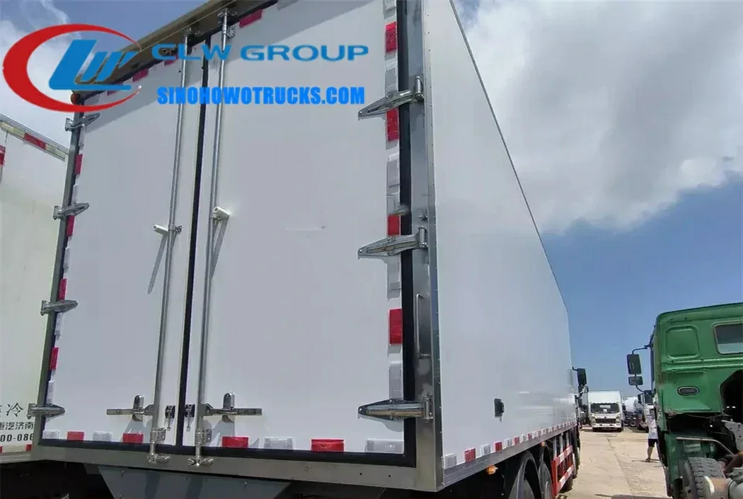 Sinotruk HOWO 25 ton freezer van in white with rear doors open, showing insulated interior and stainless steel frame