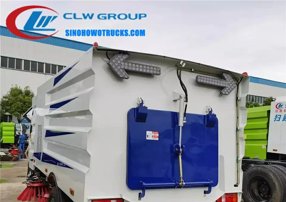 Sinotruk HOWO 5cbm street cleaner truck in urban setting with sweeping brushes in operation