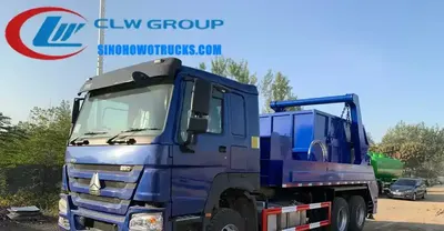 Rear view of the HOWO skip loader showing the hopper, swing arm, and hydraulic control box