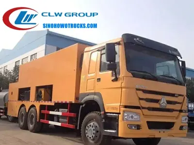 Rear view of the HOWO slurry seal truck showing the 18000 L aggregate tank and hydraulic spreading box