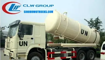 Front view of the HOWO sludge truck with cab, suction hose, and vacuum pump visible