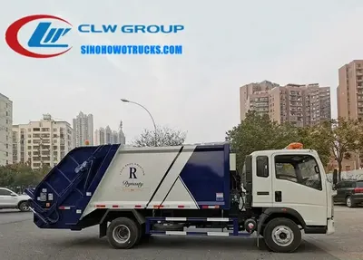 Side view of the HOWO compactor truck showing the hydraulic filler door and compaction mechanism