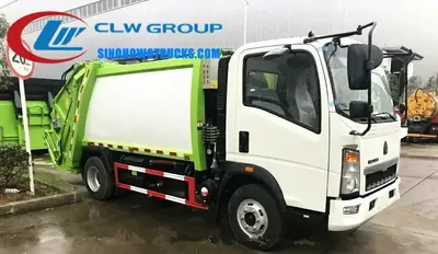 RHD HOWO 5t waste management garbage truck in urban setting with compaction body and tail gate open