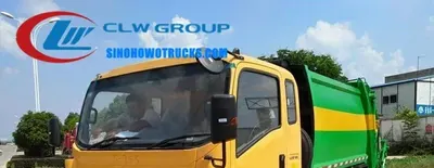 Rear view of the compactor truck with discharge door open and hydraulic system visible