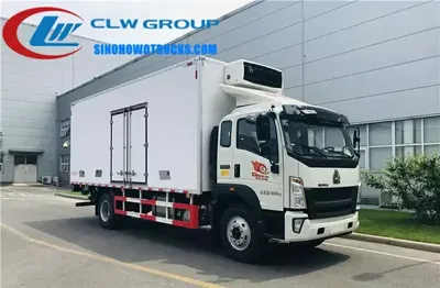 Rear view of the HOWO reefer truck with hydraulic tail lift lowered and roll carts in position