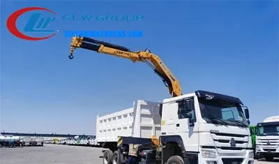 Sinotruk HOWO 10 ton tipper truck with crane in construction site environment, crane extended and body lowered