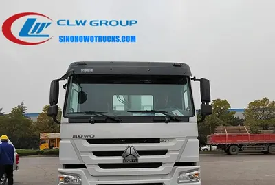 Sinotruk HOWO 12t truck mounted hydraulic crane in construction site with boom extended and operator in cab