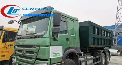 Sinotruk HOWO 6x4 roll off dump truck in urban waste collection service with 16m³ container being lifted