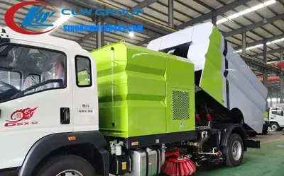 Side view of the truck-mounted sweeping machine with open dustbin and self-cleaning system in operation