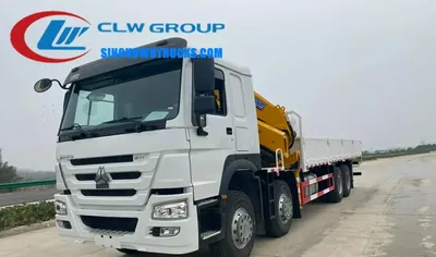 Side view of the HOWO crane truck showing the 8x4 chassis and compact hinge point design