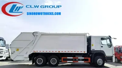 Side view of the HOWO compactor truck showing the hydraulic winch lifting a standard waste container