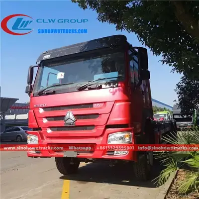 Side view of the HOWO roll off truck showing the cab, hydraulic boom, and container locking mechanism