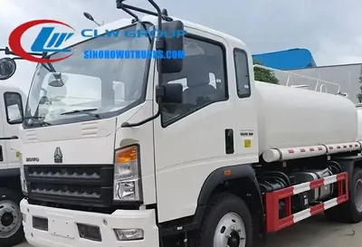 Side view of the HOWO water tanker showing front and side spray nozzles and tank access manhole