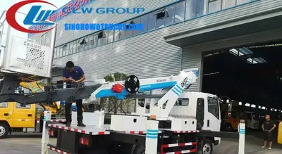 Sinotruk HOWO 21m man lifter truck in urban setting with extended boom and working basket at height
