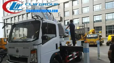 Side view of the HOWO aerial lift truck showing five-section telescopic boom and outriggers deployed