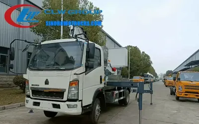 Working cage of the HOWO boom truck with safety rails and operator inside