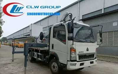 Side view of the HOWO aerial lift truck showing hydraulic outriggers and 6 tires