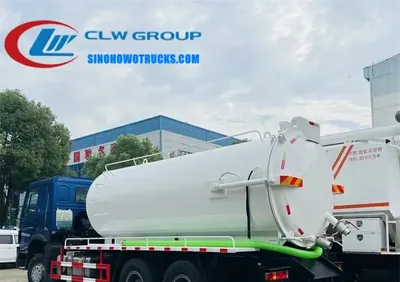 Rear view of the HOWO sewage truck showing the vacuum pump, hose reel, and hydraulic tailgate mechanism