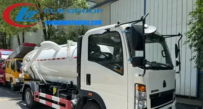 Sinotruk HOWO 5000L sewage exhauster truck in urban environment with suction hose extended