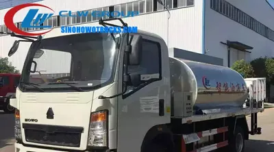 Side view of the asphalt distributor with adjustable spray width and nozzles in operation
