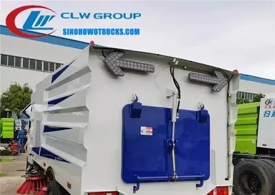 Sinotruk HOWO 5cbm street cleaner truck in urban setting with sweeping brushes in operation