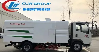 Sinotruk HOWO 4x2 road sweeper truck in urban environment with front brushes and suction nozzle in operation