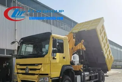 Side view of the HOWO tipper truck with crane showing folding boom and high-strength steel carriage