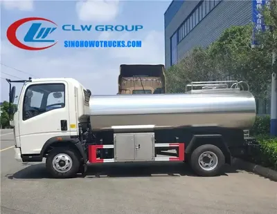 Side view of the HOWO milk truck showing the insulated tank and stainless steel valves and pipes