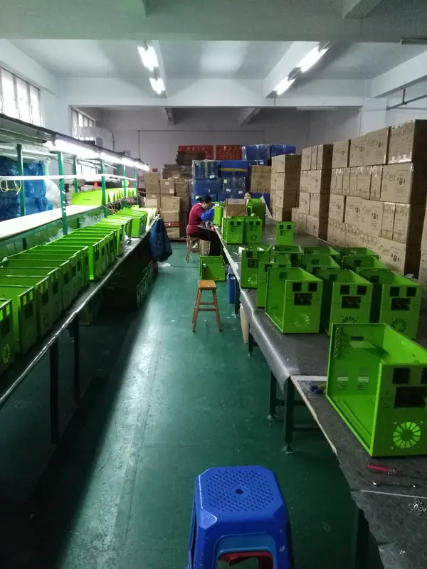 Assembly benches with finished housings staged for lamp fitting and testing.