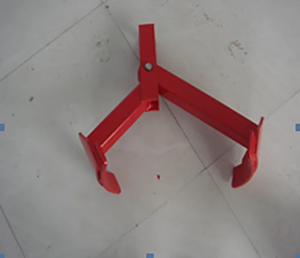 Red steel drum clutcher with paired gripping jaws on the workshop floor