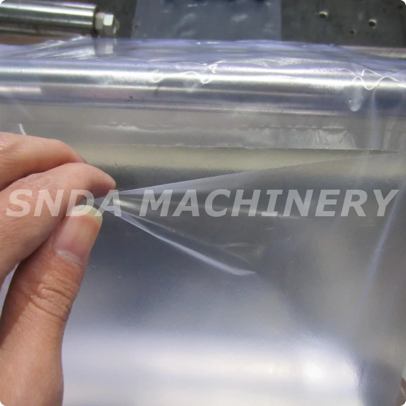 Pre-opened PE bag being fed into the Model 350 machine for automatic sealing