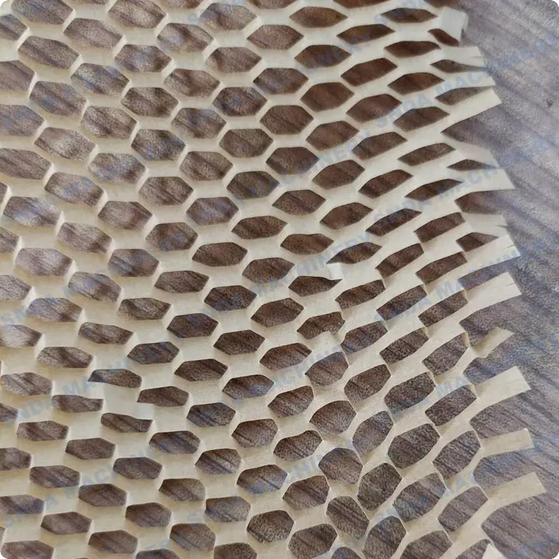 Close-up of white honeycomb paper wrap with hexagonal cells laid over a wood-grain surface, edges slightly torn