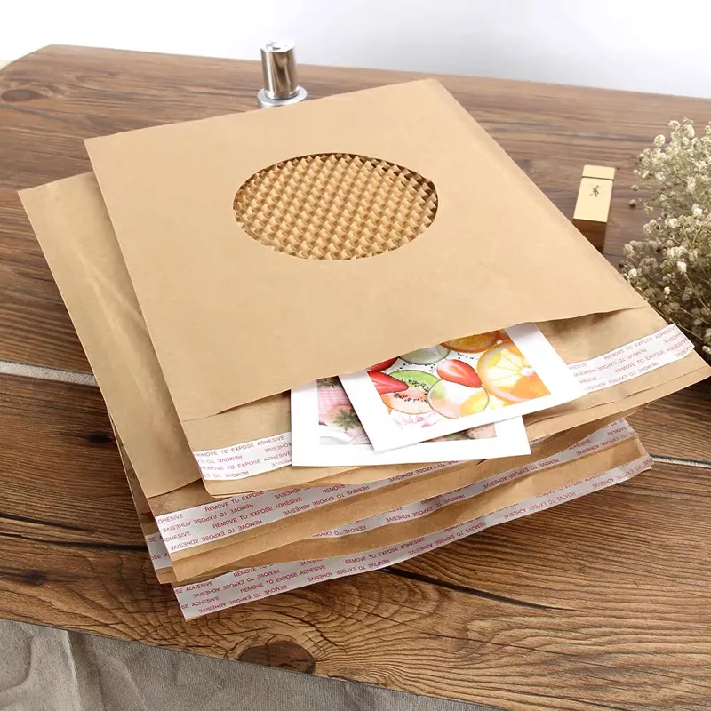 A stack of brown kraft paper bags with a window and peel-and-seal strips on a wooden table