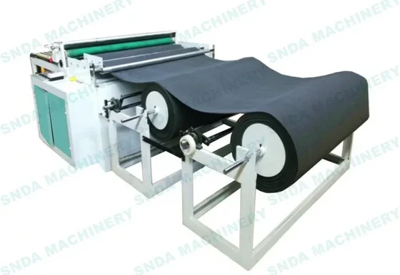 Industrial machinery processing a large roll of black material