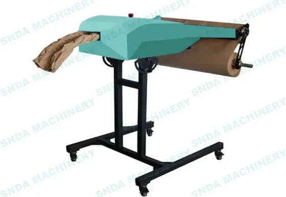 Industrial packaging machine with teal housing on a black stand, processing brown paper rolls
