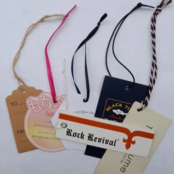 A collection of clothing hang tags with various strings and designs on a white background
