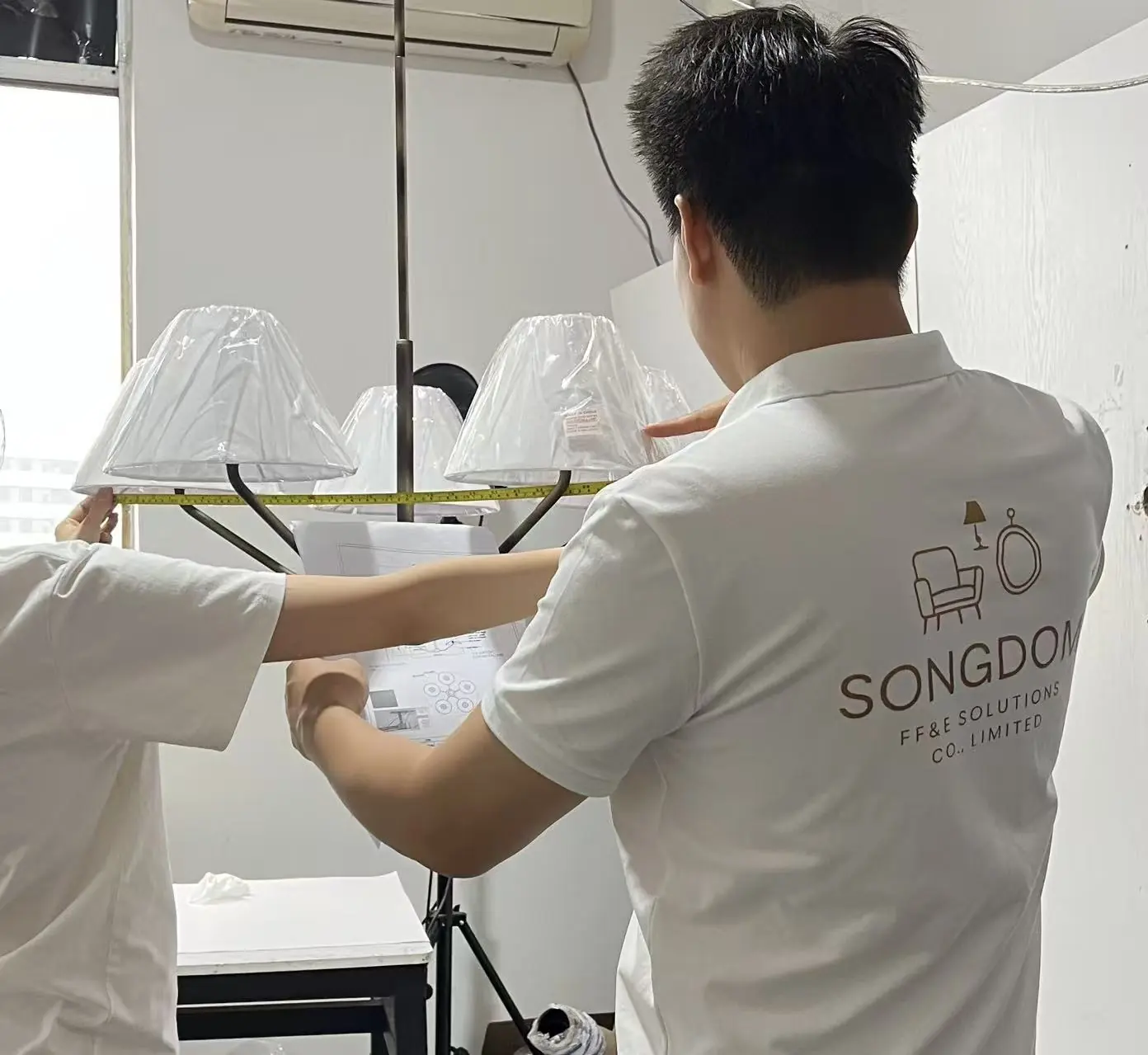 Songdom team inspecting and assembling a hospitality lighting fixture