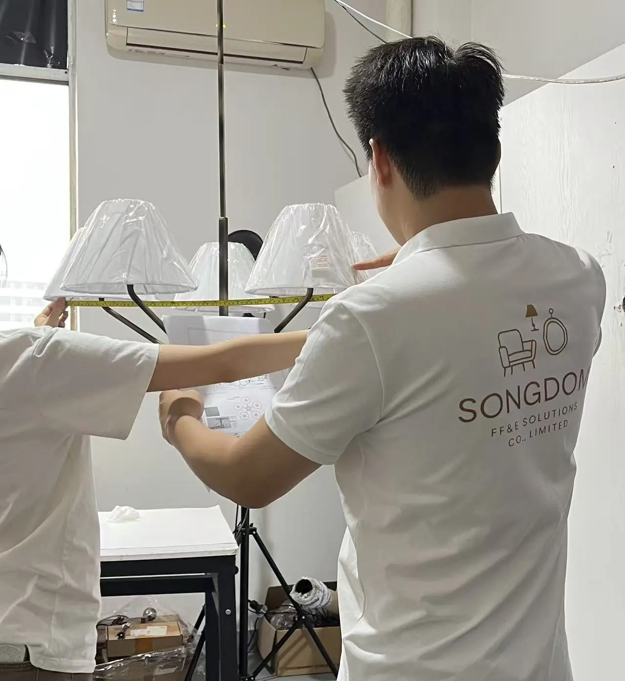 Songdom team member assembling and checking a hospitality lighting fixture