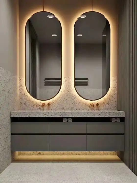 Pair of backlit LED vanity mirrors above a hotel bathroom vanity