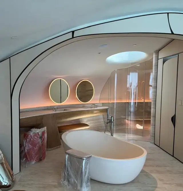 Luxury resort bathroom interior with stone bathtub and lighted mirrors