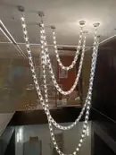 Long crystal strand chandelier in a double height space