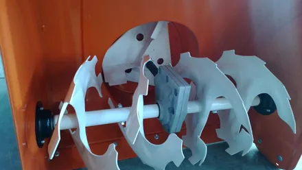 An auger and impeller assembly inside its housing, the two stage arrangement that keeps throwing distance stea