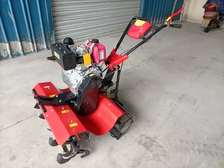 Rotary tiller viewed from the side showing handlebars and rotor housing